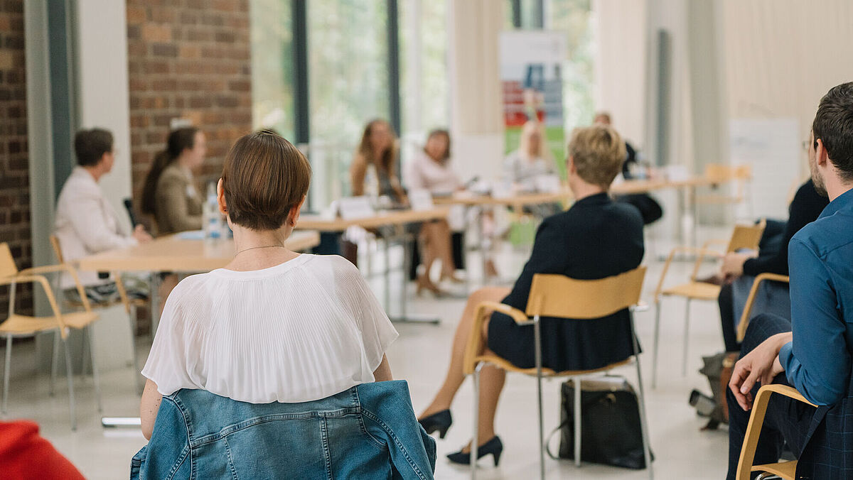 People sit at the discussion forum: 100 days of professorship and talk